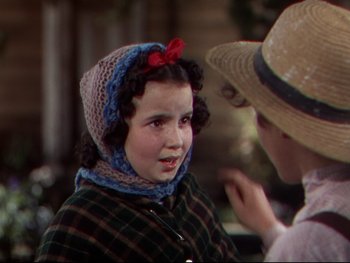 Movie still from “The Adventures of Tom Sawyer” (1938), directed by Norman Taurog – A little girl wearing a hat and a scarf is talking to a man; Close Up shot, Over the shoulder angle