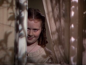 Movie still from “The Adventures of Tom Sawyer” (1938), directed by Norman Taurog – A young girl looking out of a window at the camera; Close Up shot, High angle