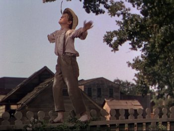 Movie still from “The Adventures of Tom Sawyer” (1938), directed by Norman Taurog – A boy in a cowboy hat is flying a kite; Wide shot, Low angle