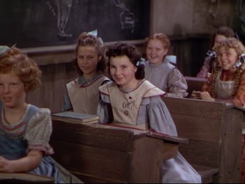 Movie still from “The Adventures of Tom Sawyer” (1938), directed by Norman Taurog – A group of children sitting at a desk in front of a chalkboard; Medium shot, High angle