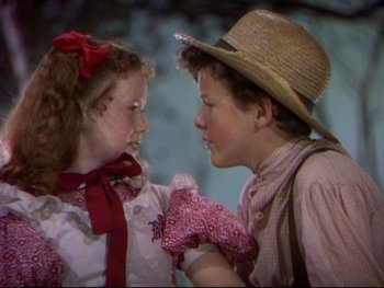 Movie still from “The Adventures of Tom Sawyer” (1938), directed by Norman Taurog – A young boy and a young girl holding hands; Close Up shot, High angle