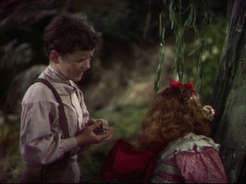 Movie still from “The Adventures of Tom Sawyer” (1938), directed by Norman Taurog – A boy and a girl are talking to each other; Medium shot, High angle