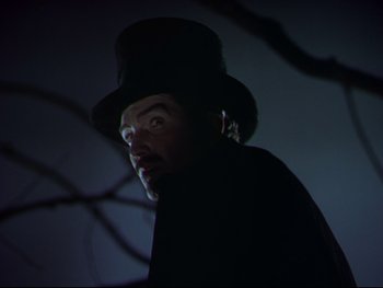 Movie still from “The Adventures of Tom Sawyer” (1938), directed by Norman Taurog – A man wearing a top hat in the dark; Close Up shot, Low angle