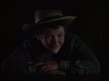 Movie still from “The Adventures of Tom Sawyer” (1938), directed by Norman Taurog – A young man wearing a straw hat is smiling for the camera; Close Up shot, High angle