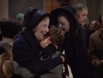 Movie still from “The Adventures of Tom Sawyer” (1938), directed by Norman Taurog – An older woman holding a young child in her arms; Medium shot, Over the shoulder angle