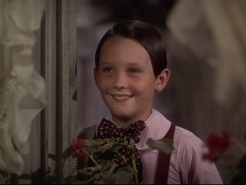Movie still from “The Adventures of Tom Sawyer” (1938), directed by Norman Taurog – A young boy wearing a pink shirt and a bow tie; Close Up shot, Over the shoulder angle