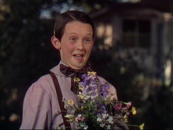 Movie still from “The Adventures of Tom Sawyer” (1938), directed by Norman Taurog – A young boy holding a bouquet of flowers; Close Up shot, Low angle