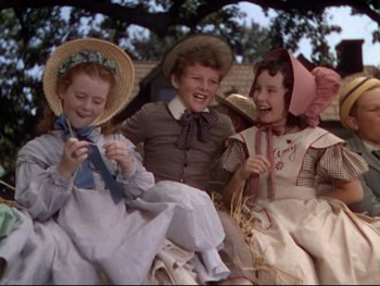 Movie still from “The Adventures of Tom Sawyer” (1938), directed by Norman Taurog – A group of children sitting on a hay bale; Medium shot, High angle