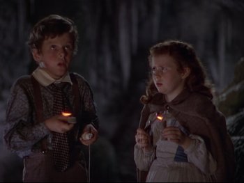 Movie still from “The Adventures of Tom Sawyer” (1938), directed by Norman Taurog – A boy and a little girl are holding candles in their hands; Medium shot, Low angle