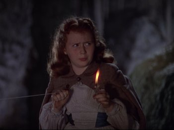 Movie still from “The Adventures of Tom Sawyer” (1938), directed by Norman Taurog – A young girl is holding a candle in a dark forest; Close Up shot, High angle