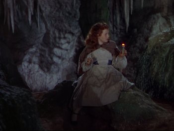 Movie still from “The Adventures of Tom Sawyer” (1938), directed by Norman Taurog – A woman holding a light in a cave; Medium shot, High angle