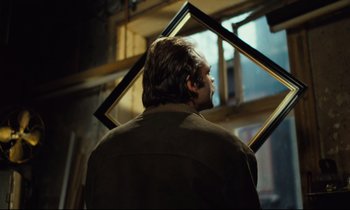 Movie still from “The American Friend” (1977), directed by Wim Wenders – A man standing in front of an open window; Close Up shot, Over the shoulder angle