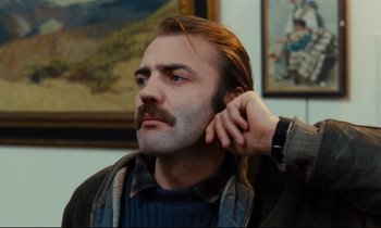 Movie still from “The American Friend” (1977), directed by Wim Wenders – A person with a mustache; Close Up shot, Low angle