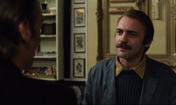Movie still from “The American Friend” (1977), directed by Wim Wenders – A man with a mustache is sitting in front of a mirror; Close Up shot, Over the shoulder angle