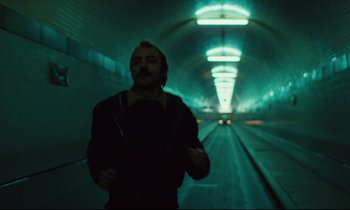Movie still from “The American Friend” (1977), directed by Wim Wenders – A man is walking in a dark tunnel; Wide shot, Low angle