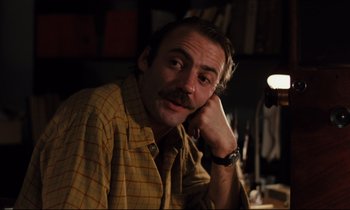 Movie still from “The American Friend” (1977), directed by Wim Wenders – A man with a mustache sitting at a table; Close Up shot, Low angle
