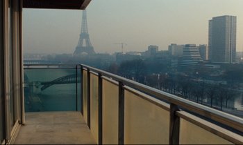 Movie still from “The American Friend” (1977), directed by Wim Wenders – A view of the eiffel tower from a balcony; Extreme Wide shot, Low angle