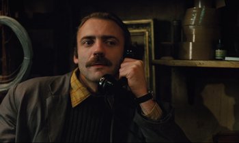 Movie still from “The American Friend” (1977), directed by Wim Wenders – A man holding a phone up to his ear; Close Up shot, Low angle