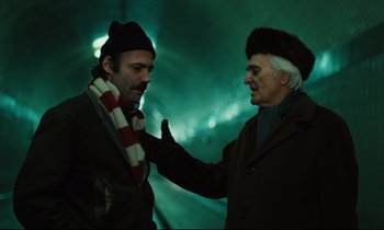 Movie still from “The American Friend” (1977), directed by Wim Wenders – Two men are standing in a tunnel looking at each other; Medium shot, Over the shoulder angle