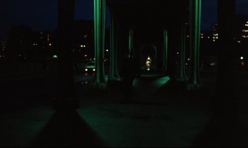 Movie still from “The American Friend” (1977), directed by Wim Wenders – A person is standing in the dark at night; Extreme Wide shot, High angle