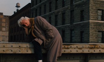 Movie still from “The American Friend” (1977), directed by Wim Wenders – An older woman leaning on a rail while talking on the phone; Wide shot, High angle