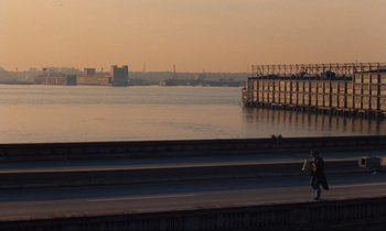 Movie still from “The American Friend” (1977), directed by Wim Wenders – A body of water with a bridge in the background; Extreme Wide shot, High angle