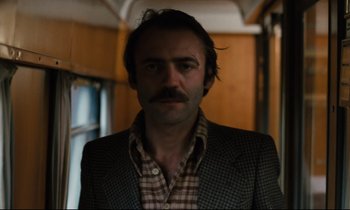 Movie still from “The American Friend” (1977), directed by Wim Wenders – A man in a jacket and a plaid shirt; Close Up shot, Low angle