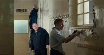 Movie still from “The Angels' Share” (2012), directed by Ken Loach – A group of men standing next to each other in a room; Medium shot, Over the shoulder angle