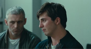 Movie still from “The Angels' Share” (2012), directed by Ken Loach – A young man with short brown hair looks to his left; Close Up shot, Over the shoulder angle