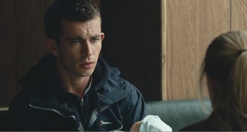 Movie still from “The Angels' Share” (2012), directed by Ken Loach – A man sitting on top of a couch next to a window; Close Up shot, Over the shoulder angle