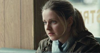 Movie still from “The Angels' Share” (2012), directed by Ken Loach – A young woman with blue eyes is looking at the camera; Close Up shot, Over the shoulder angle