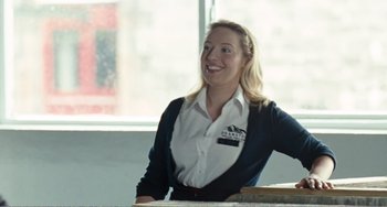 Movie still from “The Angels' Share” (2012), directed by Ken Loach – A woman sitting at a table in front of a window; Medium shot, Low angle