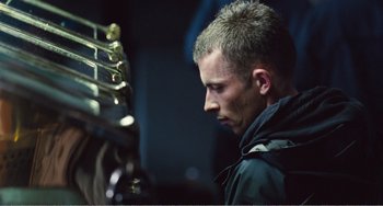 Movie still from “The Angels' Share” (2012), directed by Ken Loach – A person in a black jacket; Close Up shot, Low angle