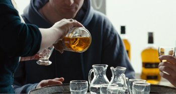 Movie still from “The Angels' Share” (2012), directed by Ken Loach – A man pouring a beverage into a glass; Extreme Close Up shot, Over the shoulder angle