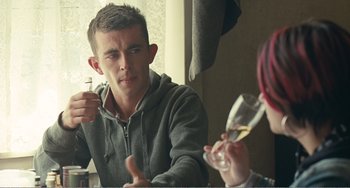 Movie still from “The Angels' Share” (2012), directed by Ken Loach – A man and a woman sitting at a table drinking wine; Medium shot, Over the shoulder angle