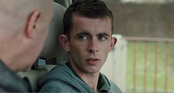 Movie still from “The Angels' Share” (2012), directed by Ken Loach – A young man sitting in the back seat of a car; Close Up shot, Over the shoulder angle