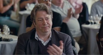 Movie still from “The Angels' Share” (2012), directed by Ken Loach – A man clapping his hands in front of a group of people; Close Up shot, Over the shoulder angle