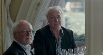 Movie still from “The Angels' Share” (2012), directed by Ken Loach – A man sitting at a table in front of a bunch of wine glasses; Close Up shot, Over the shoulder angle