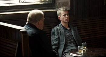 Movie still from “The Angels' Share” (2012), directed by Ken Loach – Two men sitting at a table in front of each other; Medium shot, Over the shoulder angle