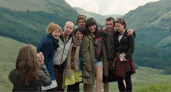Movie still from “The Angels' Share” (2012), directed by Ken Loach – A group of people posing for a picture in front of mountains; Wide shot, High angle