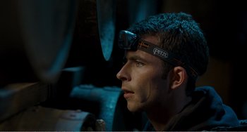 Movie still from “The Angels' Share” (2012), directed by Ken Loach – A man with a head lamp on his head; Close Up shot, Over the shoulder angle