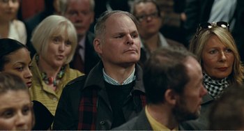 Movie still from “The Angels' Share” (2012), directed by Ken Loach – An older man is looking up at a crowd; Medium shot, Over the shoulder angle