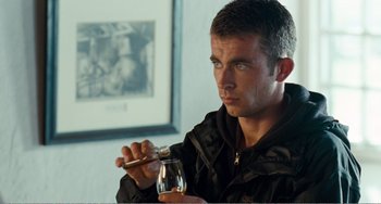 Movie still from “The Angels' Share” (2012), directed by Ken Loach – A man holding a glass of wine and a spoon; Close Up shot, Over the shoulder angle