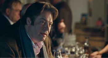 Movie still from “The Angels' Share” (2012), directed by Ken Loach – A person sitting at a table with a glass of wine; Close Up shot, Over the shoulder angle