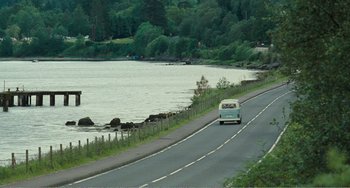 Movie still from “The Angels' Share” (2012), directed by Ken Loach – A van driving down a road next to a body of water; Extreme Wide shot, High angle