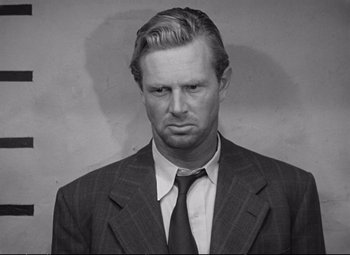 Movie still from “The Asphalt Jungle” (1950), directed by John Huston – Black and white photograph of a man wearing a suit and tie; Close Up shot, Low angle