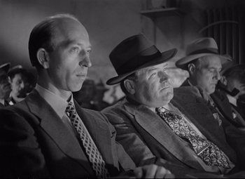 Movie still from “The Asphalt Jungle” (1950), directed by John Huston – A black - and - white photo of a group of men in suits and hats; Medium shot, Low angle