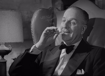 Movie still from “The Asphalt Jungle” (1950), directed by John Huston – An older man smoking a cigarette while wearing a suit and bow tie; Close Up shot, Low angle