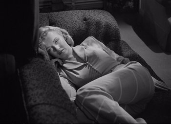 Movie still from “The Asphalt Jungle” (1950), directed by John Huston – A woman laying on a couch in a living room; Medium shot, High angle