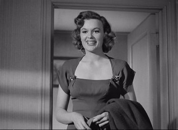 Movie still from “The Asphalt Jungle” (1950), directed by John Huston – A black - and - white photo of a woman in a dress; Medium shot, Low angle